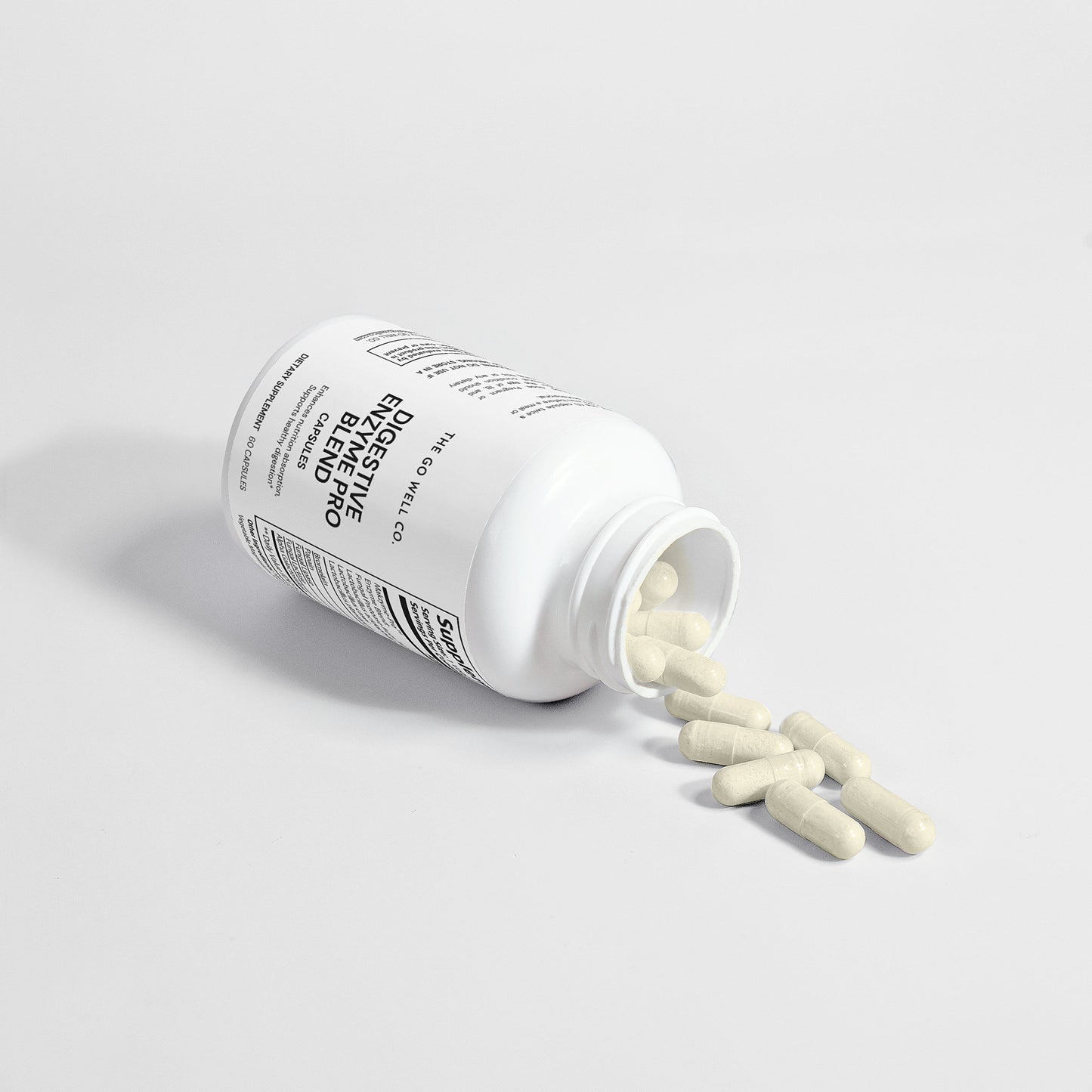 Open white supplement bottle with pills spilling out on a light gray background