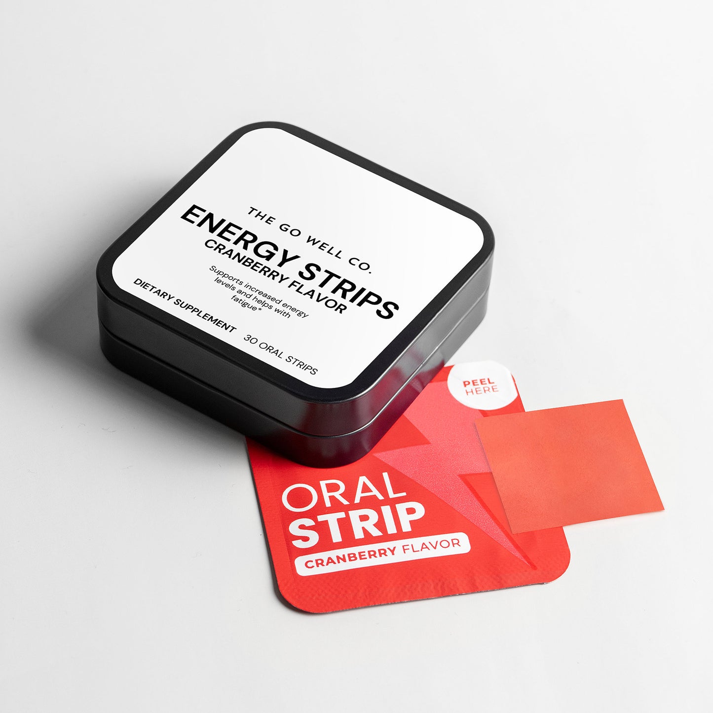 Box of The Go Well Co. energy strips with a single strip on a gray background
