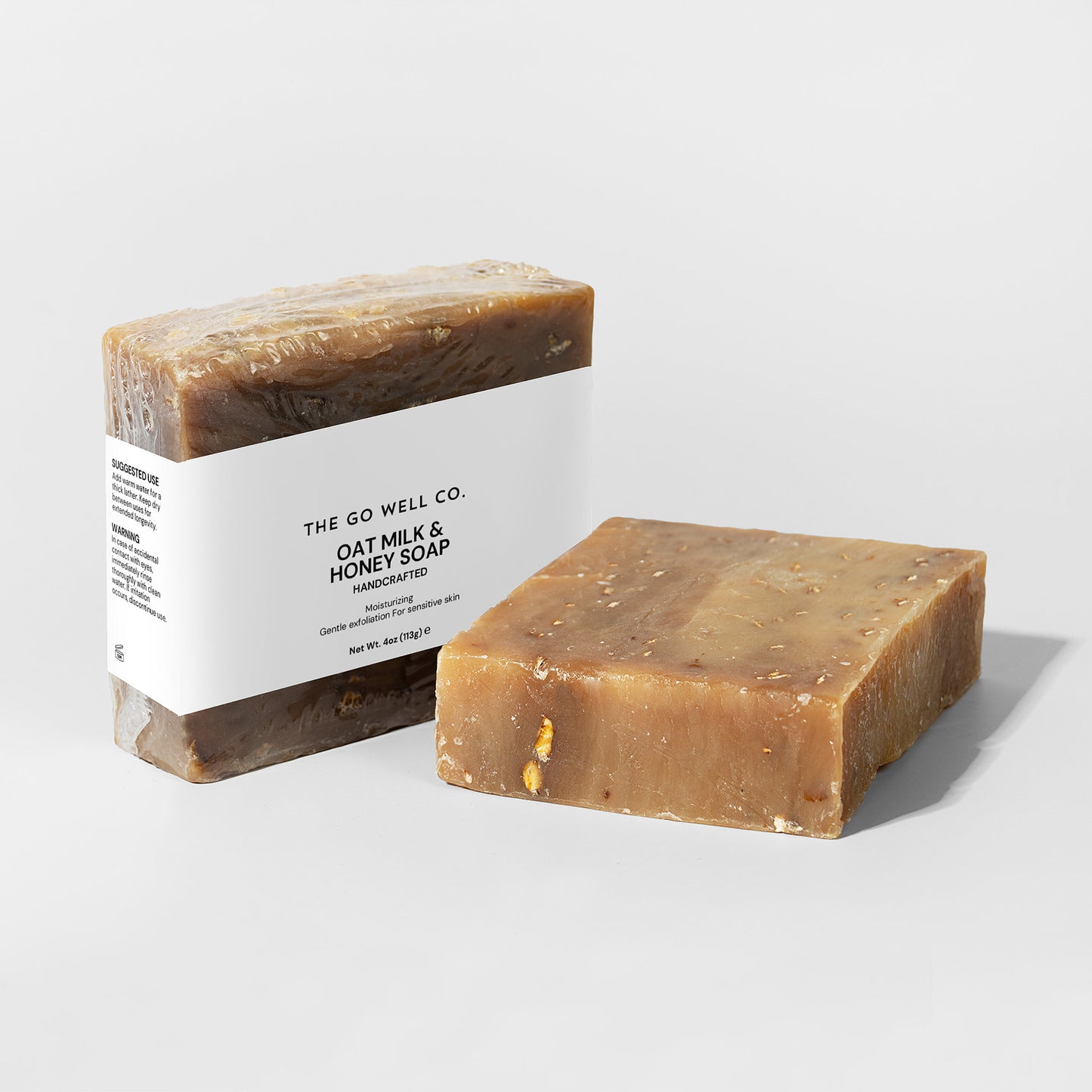 Two bars of soap, one with a visible label, on a light gray background.