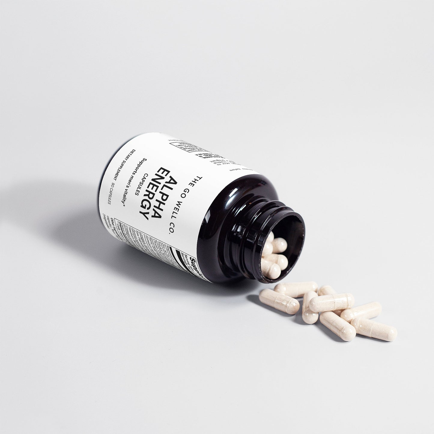 Alpha Energy supplement bottle with pills spilling out on a light gray background