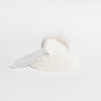 White powder in a clear plastic scoop on a light gray background
