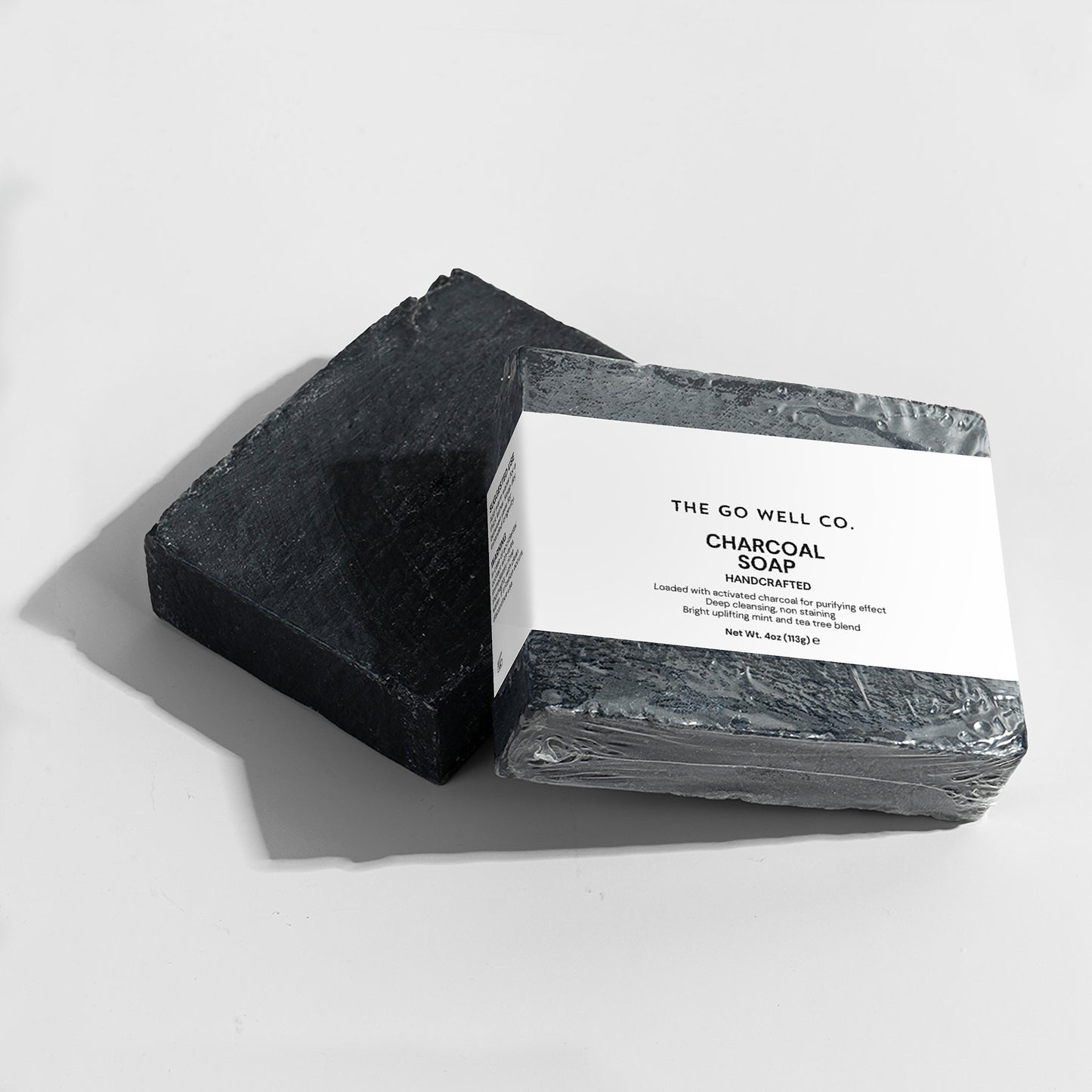 Two bars of charcoal soap from The Go Well Co. on a white background