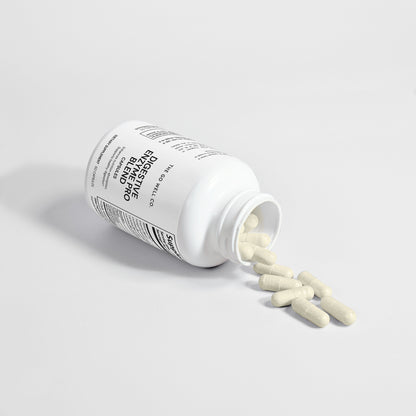 Open white supplement bottle with pills spilling out on a light gray background