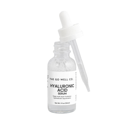 Hyaluronic acid serum bottle with dropper labeled 'The Go Well Co.' on a light gray background