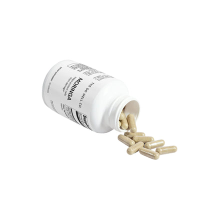 Open supplement bottle with capsules spilling out on a light gray background
