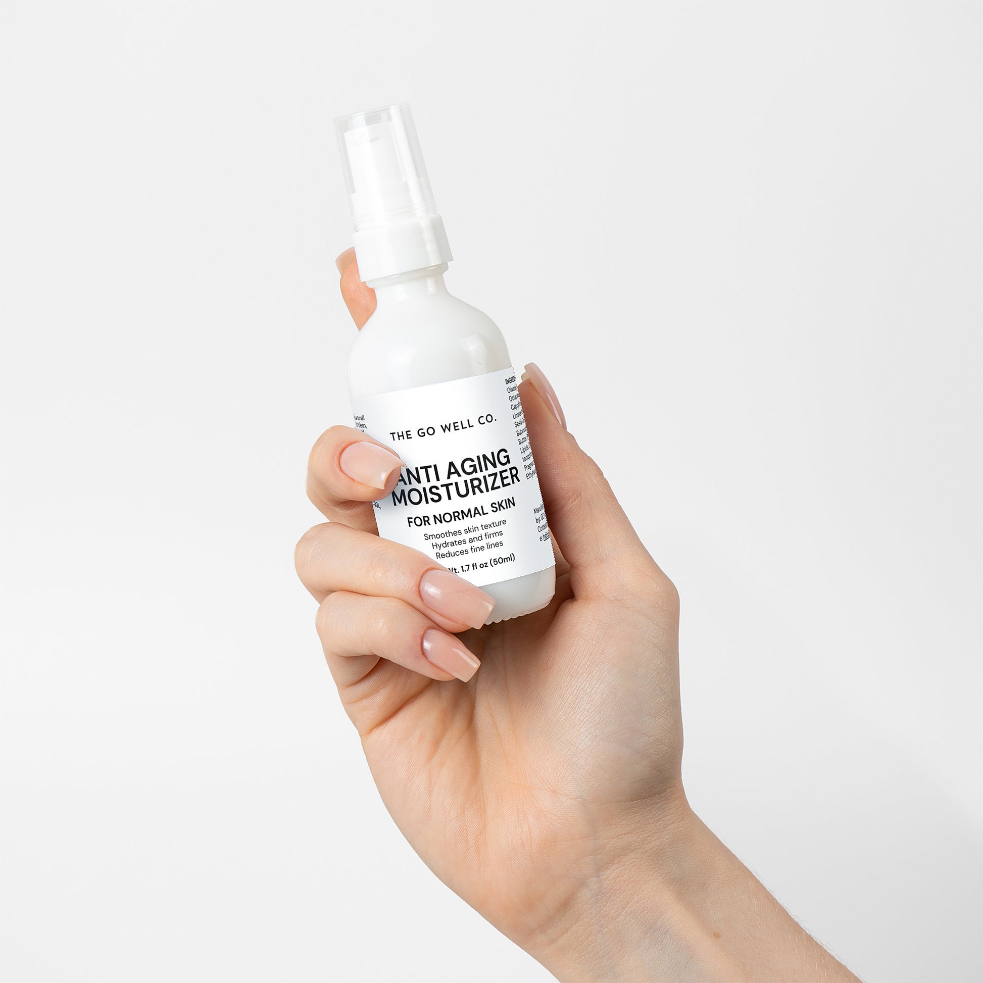 Hand holding a bottle of 'The Go Well Co.' anti-aging moisturizer against a white background